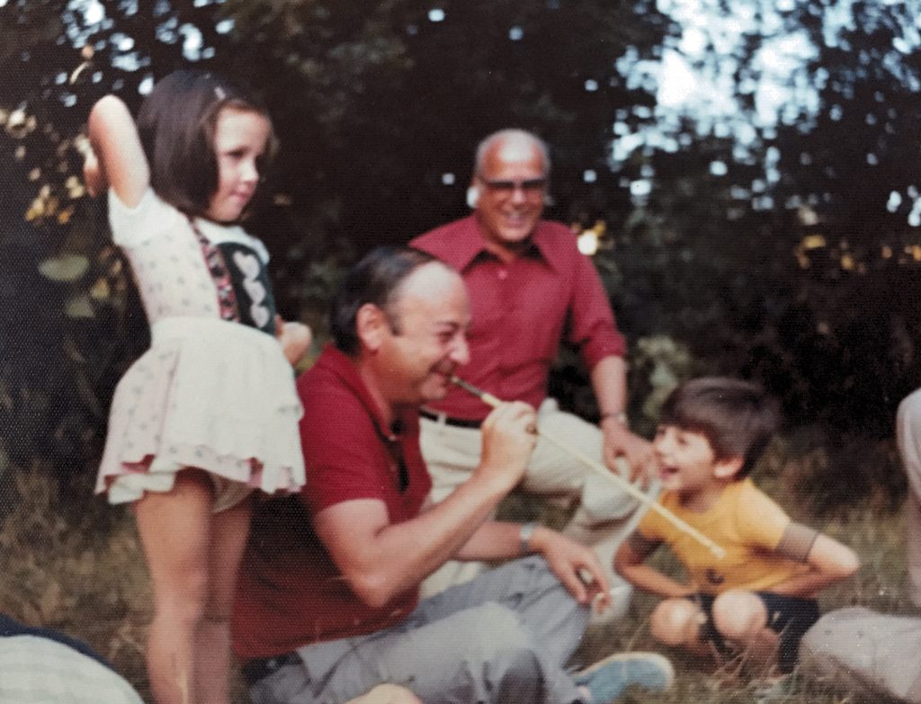 Padre enseñando a sus hijos a tirar con cerbatana en los años setenta