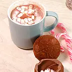 Vierte leche caliente encima de la bola de chocolate y observa cómo se derrite