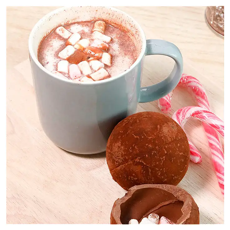 Vierte leche caliente encima de la bola de chocolate y observa cómo se derrite