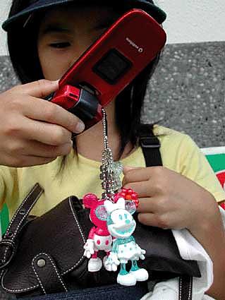 Una joven japonesa con varios colgantes en su móvil