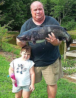 Grandad holding the record-fish, little granddaughter holding Barbie rod
